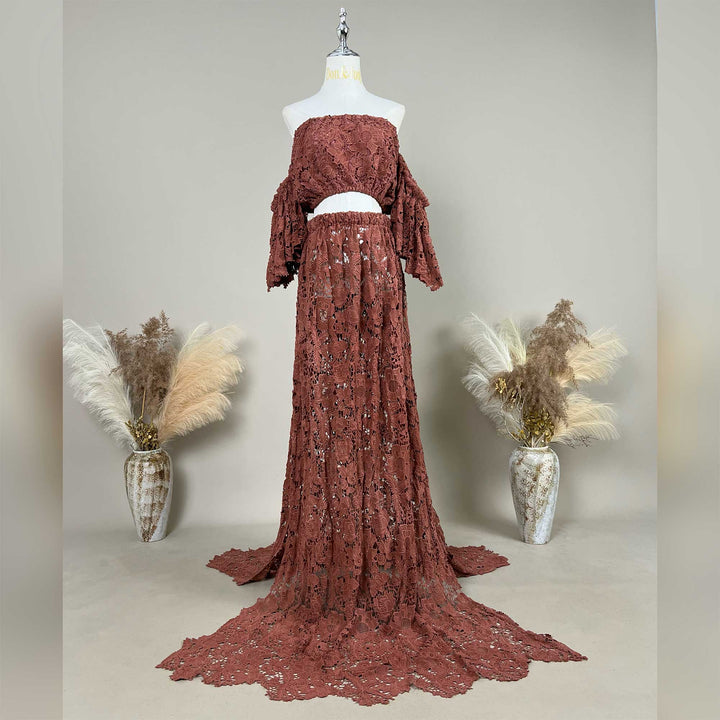 The Bendis,terracotta two-piece lace maternity photography set displayed on a mannequin, featuring an off-the-shoulder ruffled crop top and a high-waisted floor-length skirt with a sweeping train