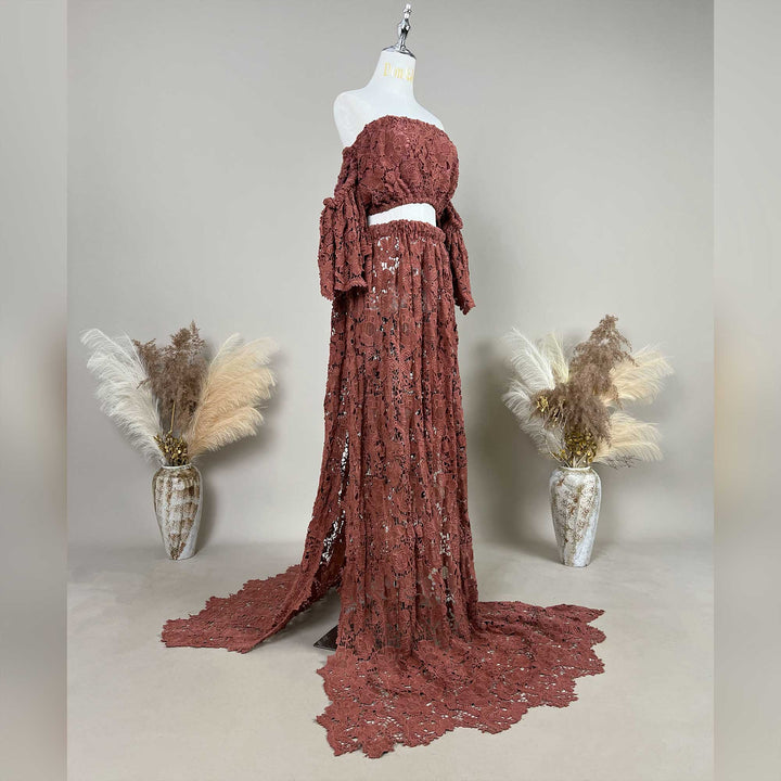 A terracotta,Bendis two-piece displayed on a mannequin, featuring an off the shoulder ruffled crop top and a high waisted floor length skirt with a sweeping train.
