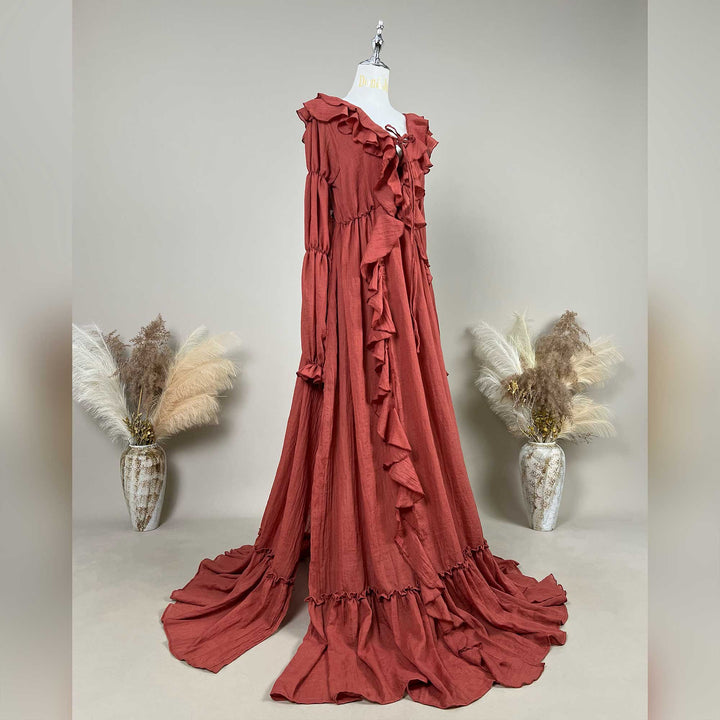 A Terracotta, Kallectoria dress with ruffle details is displayed on a mannequin against a neutral gray background.